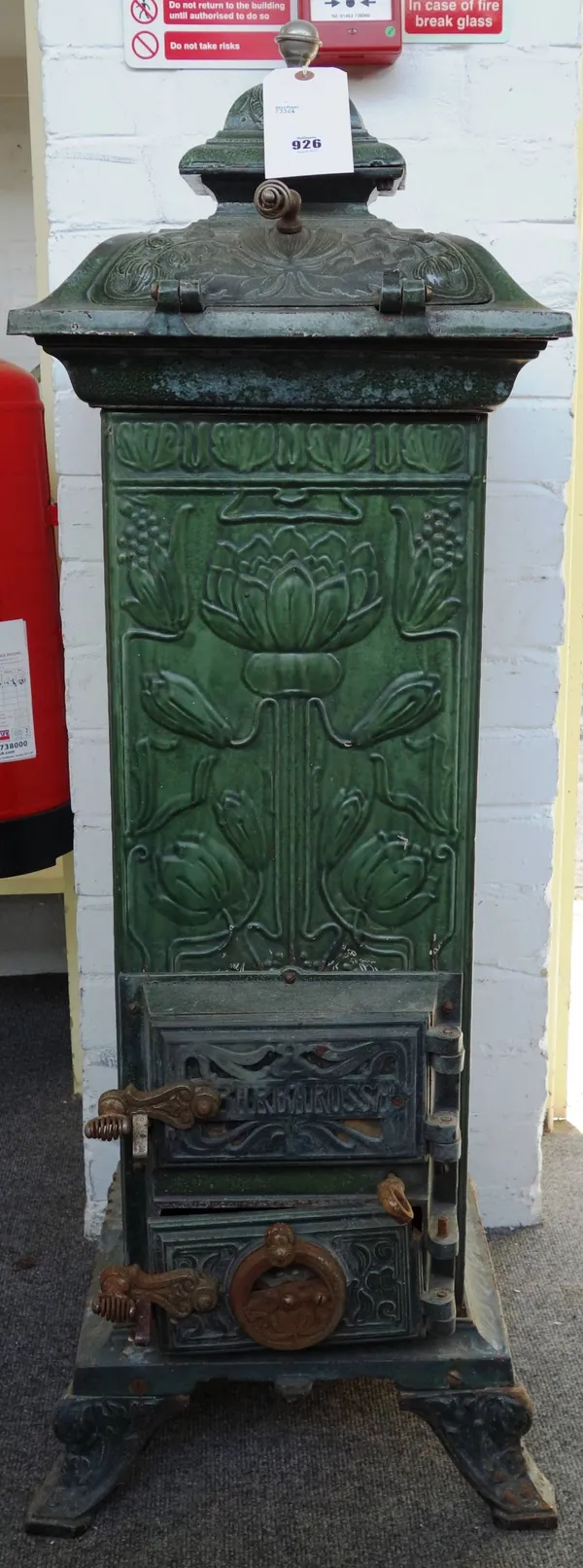 A Continental cast iron cathedral heater, early 20th century, green painted and relief cast with Art Nouveau flowers, on four shaped feet, 108cm high.