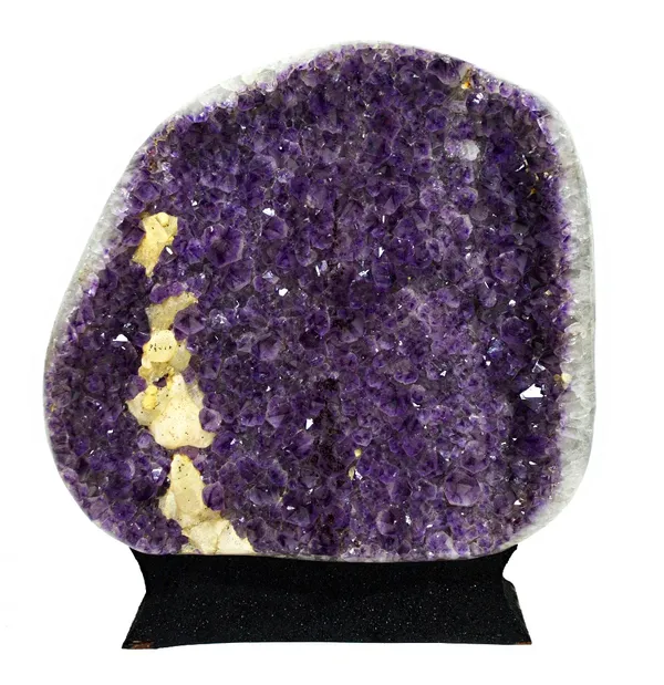 A specimen of Amethyst Minas Gerais, Brazil, of concave form, with a cluster of calcite crystals, raised on an ebonised naturalistic plinth, 54cm high