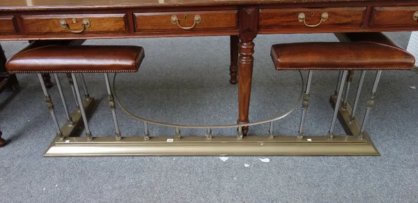 A Victorian style gilt metal and leather club fender, 20th century, with acanthus casting to the pillar rails, plinth base and brown leather upholster