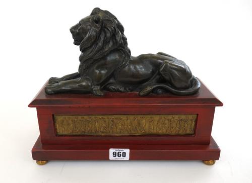 A pair of modern bronze lions raised on wooden plinths and spherical brass feet, 29cm wide and a set of brass and mahogany postal scales with associat