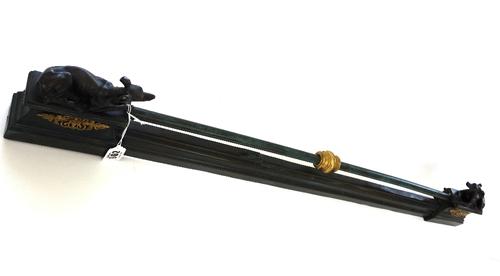 A French Restauration bronze adjustable fender, 19th century, (with later restorations), with green patina and tubular rail, flanked by two recumbent