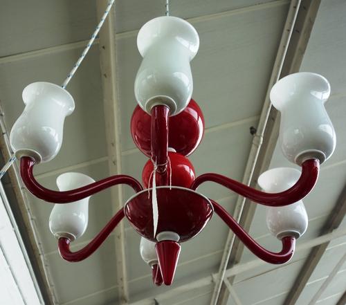 A Venetian Murano red and white glass six branch chandelier, 20th century, the globular stem issuing six scroll arms with tulip shaped shades, 85cm hi