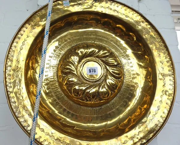 A Nuremberg brass alms dish, 17th century, with a central foliate boss and band of script (a.f), 46cm diameter.