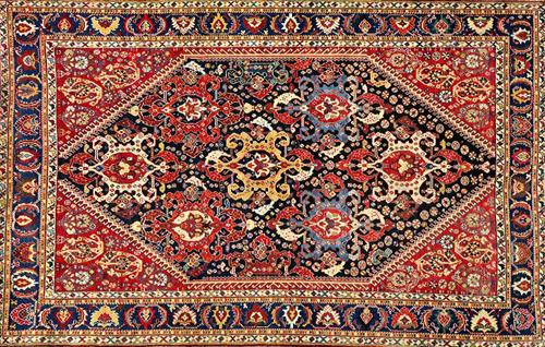 A Ghasghai rug, South Persian, the indigo field with seven shaped hooked medallions, minor motifs, hooked madder spandrels, with two boteh, an indigo