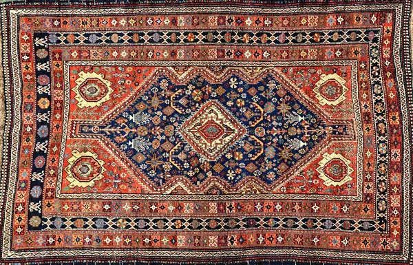 A Ghasghai rug, South Persian, the indigo field with an ivory diamond, madder spandrels, all with minor motifs, three borders, 240cm x 159cm.  Illustr