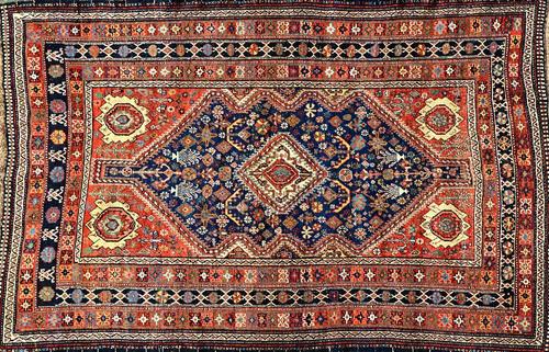 A Ghasghai rug, South Persian, the indigo field with an ivory diamond, madder spandrels, all with minor motifs, three borders, 240cm x 159cm.  Illustr
