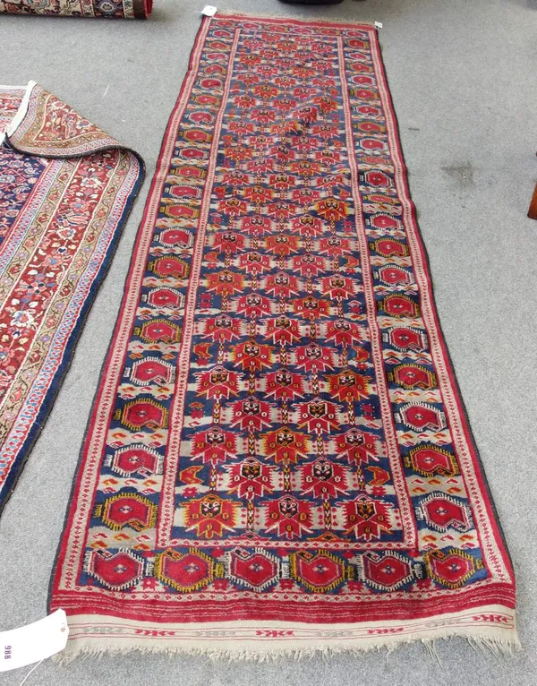 A Beshir runner, Turkman, the indigo field with rows of stylised madder flowerheads, a complementary boteh border, 295cm x 81cm.