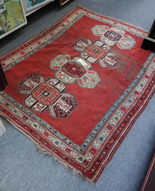 A Karajar rug, Caucasian, the plain madder field with four stylised crosses, a bird and leaf border, 180cm x 144cm.