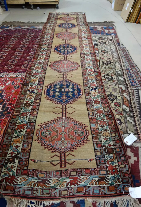 A Sarab runner, Persian, the camel field with seven medallions, three borders, 429cm x 97cm.