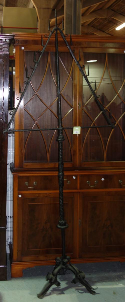 A wrought iron ecclesiastical altar candlestick on a triform foliate base, 223cm high.   G6
