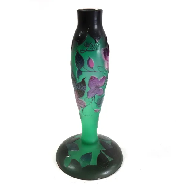 A Galle style glass lamp base relief decorated with purple blooms against a green ground on a wide spreading foot, signed Galle, 32cm high.