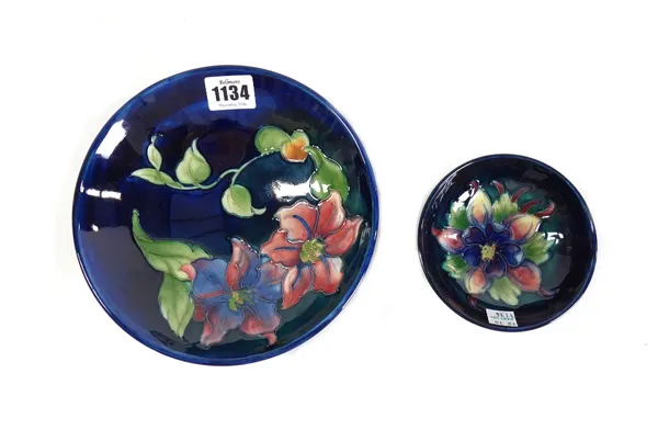 A Moorcroft pottery 'Anemone' footed bowl, circa 1930, tube line decorated against a cobalt blue ground, 18.5cm diameter, and a similar smaller Moorcr