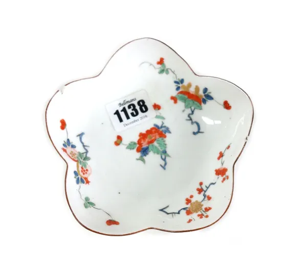 A rare and early Meissen lobed small dish, circa 1730, painted in the kakiemon palette with scattered flowers and fruit, caduceus mark in underglaze b
