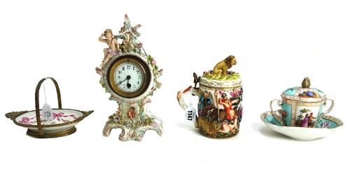 A Capodimonte tankard with lion finial to the hinged lid, relief moulded with a battle scene, 16cm high, a Continental porcelain mantel clock, 24cm hi
