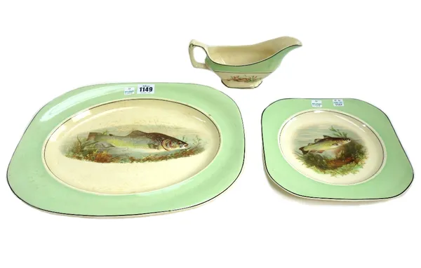 A Woods ivory ware fish service, 20th century, decorated with fish within a wide green border, comprising; a pair of platters, 35cm wide, two sauce bo