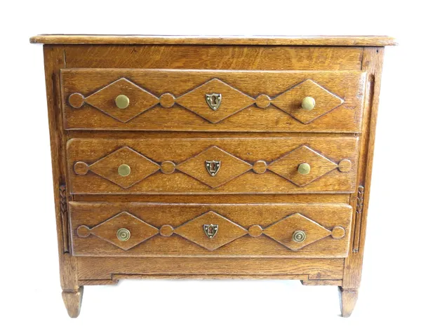 A small provincial French oak commode of 18th century design, with three long diamond moulded drawers, on tapering square supports, 52cm wide.