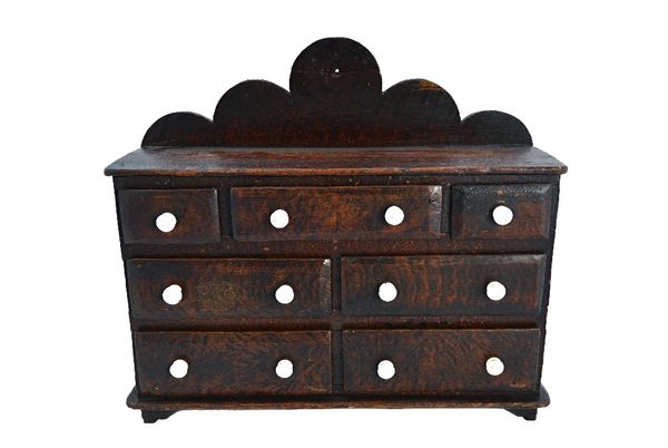 A scumble painted miniature pine dresser base of seven various drawers, on bracket feet, 43cm wide.  Illustrated