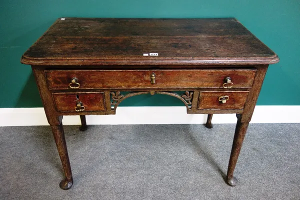 An 18th century oak lowboy, with three drawers about the pierced and carved frieze, on club supports, 99cm wide.