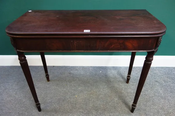 A George III mahogany tea table, the fold over rounded rectangular top on tapering reeded supports, 91cm wide.