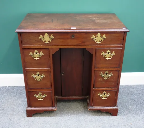 A mid-18th century mahogany kneehole writing desk, with seven drawers about the central cupboard, on bracket feet, 80cm wide.