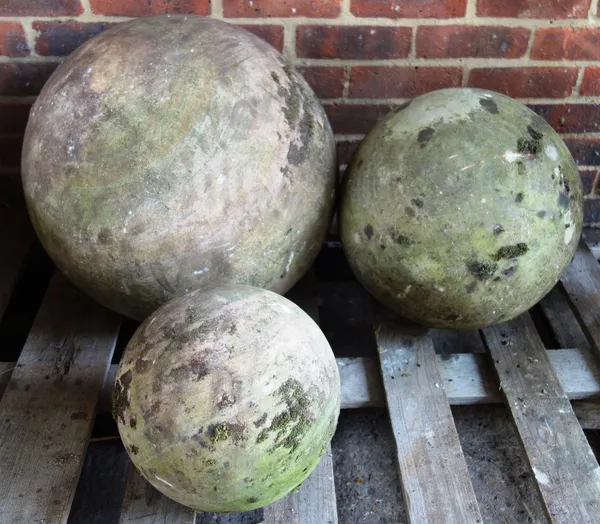 A set of three graduated sandstone atlas balls (3).