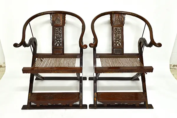 A pair of late 19th/early 20th century Chinese metal banded horse shoe back folding chairs, with pierced splats, 131cm high.