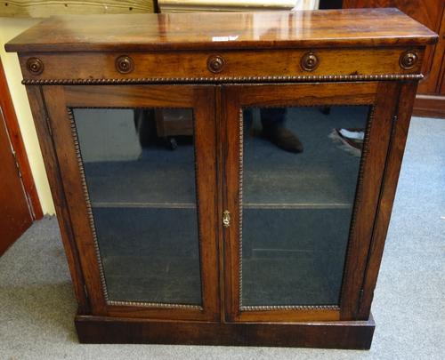 A William IV rosewood side cabinet, with pair of glazed doors on plinth base, 85cm wide.