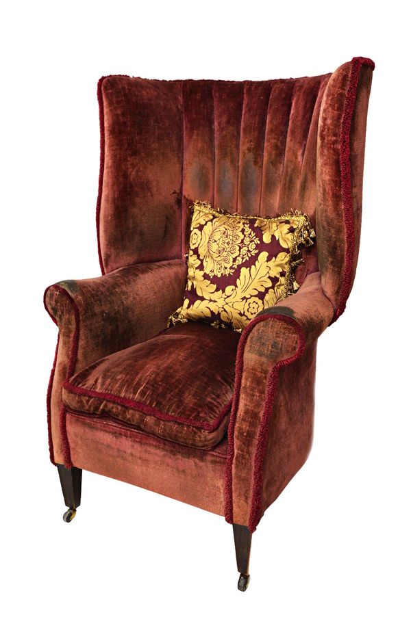 A 19th century high tub back armchair of 18th century design, with outswept arms, on tapering square supports.  Illustrated