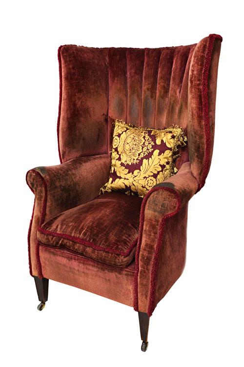 A 19th century high tub back armchair of 18th century design, with outswept arms, on tapering square supports.  Illustrated