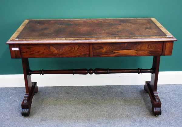 A William IV rosewood library table, the rectangular leather inset top over a pair of flush fit frieze drawers, on trestle end standards, united by tu