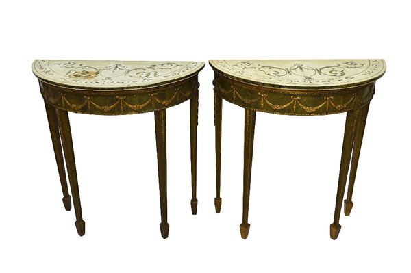 A pair of consoles circa 1900, each with inlaid marble tops over a green and parcel gilt base with floral tied swag decoration on tapering square supp