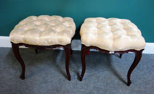 A pair of late 19th century French carved walnut square foot stools of serpentine outline on slender cabriole supports, 51cm wide.