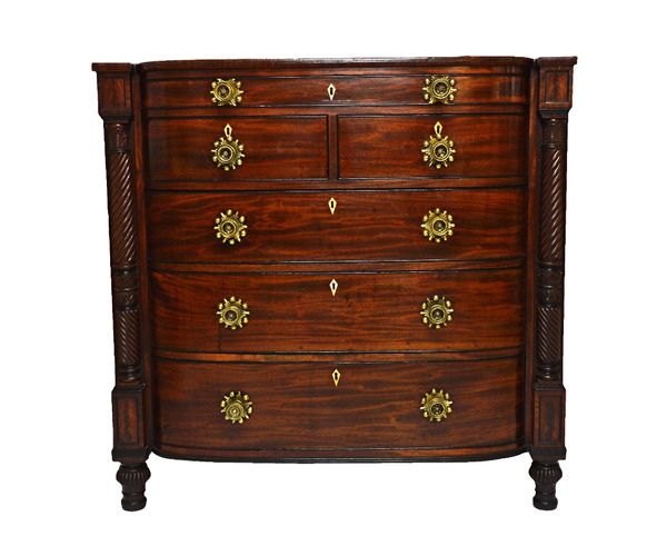 An early 19th century Scottish mahogany bow front chest, with one long over two short and three long drawers, flanked by split spiral fluted columns,