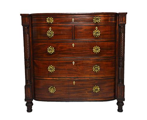 An early 19th century Scottish mahogany bow front chest, with one long over two short and three long drawers, flanked by split spiral fluted columns,