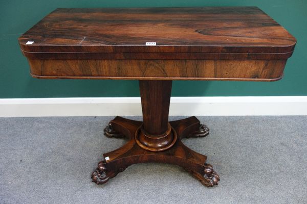 An early Victorian rosewood games table, on tapering octagonal column, lozenge platform and four lions paw feet, 92cm wide.