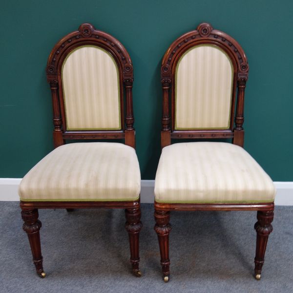 A set of eight late Victorian walnut dining chairs, each with arched padded back and straight front seat, on carved tapering fluted supports (8).