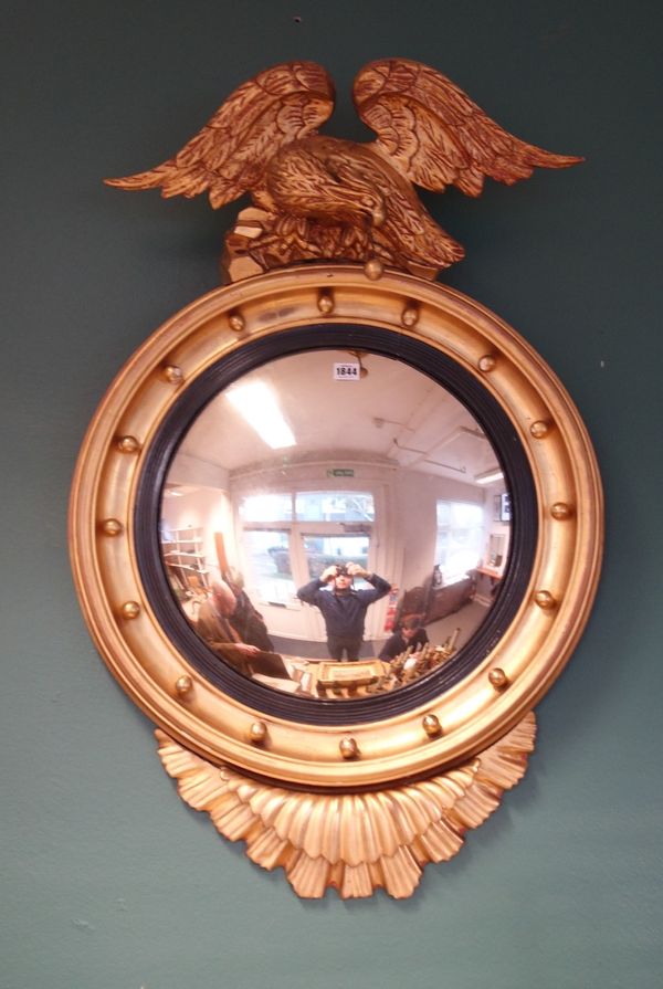 A Victorian gilt framed convex mirror, with eagle crest and ebonised slip, 65cm wide x 100cm high, together with another circular gilt framed wall mir