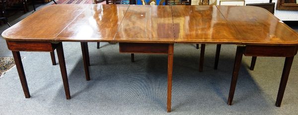 A George III mahogany chequer strung extending dining table, with pair of 'D' ends, central section and one extra leaf, on tapering square supports, 1