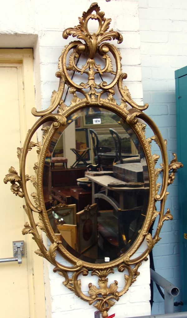 A George III and later gilt framed mirror, with opposing C scroll upper and lower frieze about the bevelled mirror plate, 138cm high x 81cm wide.