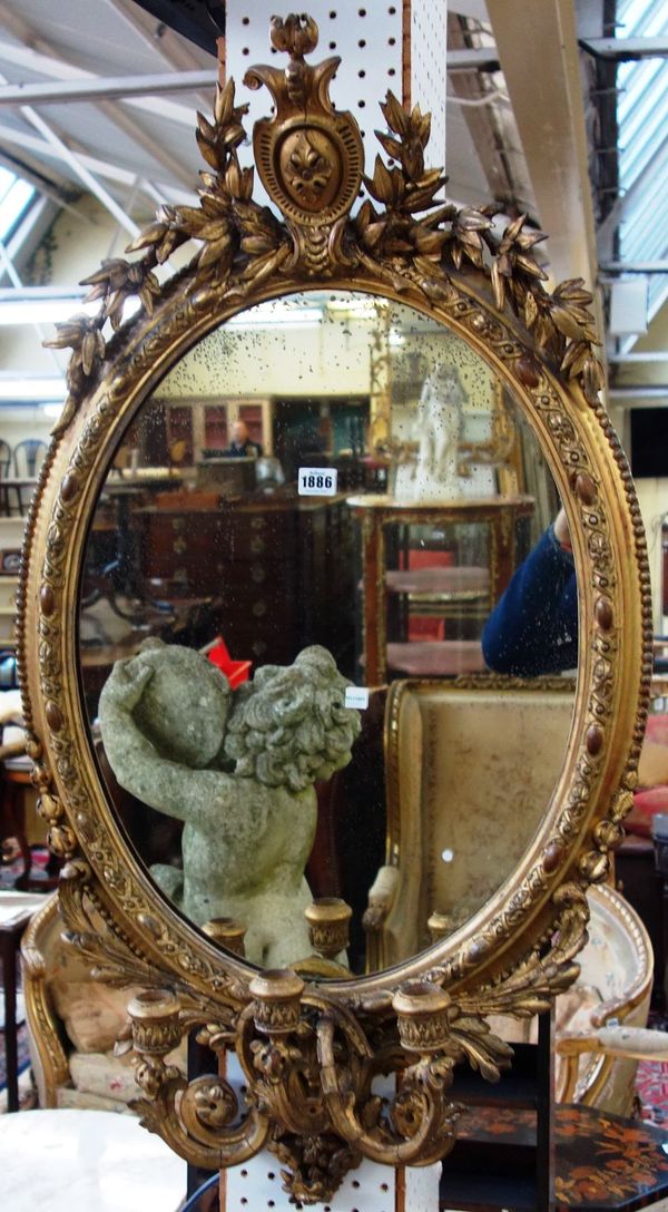 A 19th century gilt framed oval mirror with floral chased frame and triple branch girandole, 56cm wide x 100cm high.