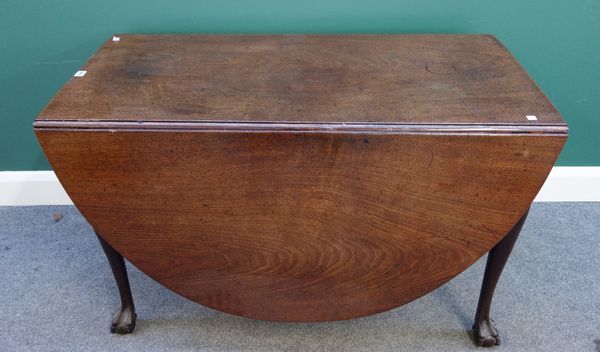 A mid 18th century mahogany drop flap dining table, the oval top on club supports terminating in ball and claw feet, 117cm x 169cm.