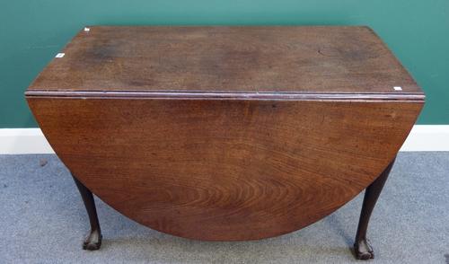 A mid 18th century mahogany drop flap dining table, the oval top on club supports terminating in ball and claw feet, 117cm x 169cm.