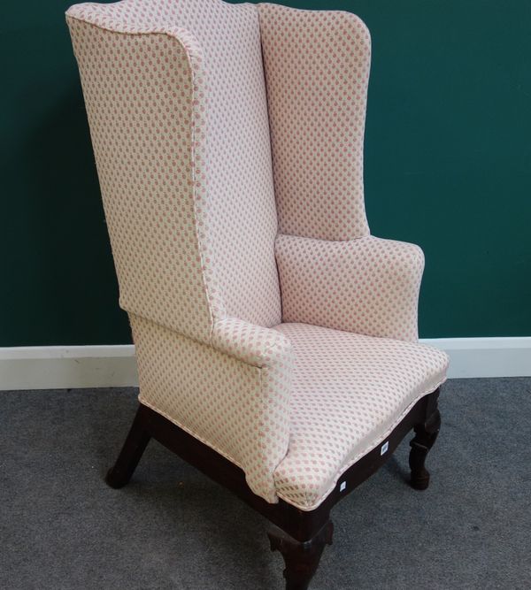 An early 18th century and later wing back armchair on squat cabriole supports.