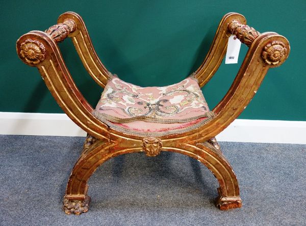 A 19th century Italian giltwood  X frame stool, on paw feet, 81cm wide.