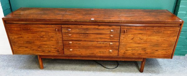 Probably Archie Shine; a mid-20th century rosewood sideboard, with fitted hot plate over four drawers flanked by cupboards, 214cm wide. (To be sold wi