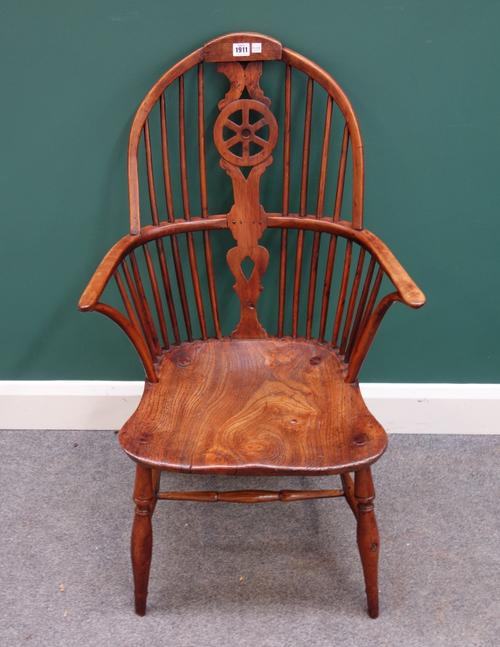 A George III yew and elm wheel back Windsor armchair on turned supports.