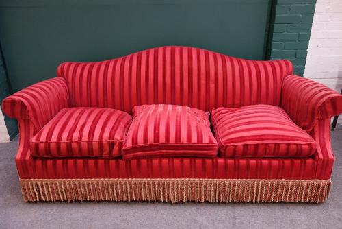 Kingcome Sofa Ltd; a 20th century striped red upholstered hump back sofa with tassel frieze, 215cm wide.