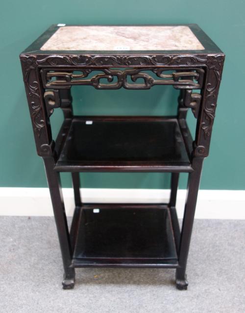 An early 20th century Chinese jardininere stand, the rectangular marble inset top over pierced frieze and twin level undertier, on ball and claw feet,