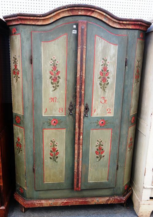 An early 19th century Tyrolean painted two door armoire dated 1812, with rose vignettes on a pale green grey ground, 124cm wide x 190cm high.Provenanc