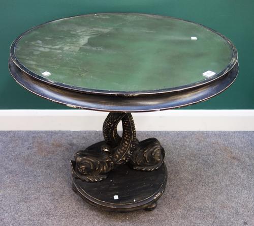 A George II style mirror top ebonised round table, on addorsed dolphin supports, 80cm diameter.Provenance- from the estate of Fleur Cowles